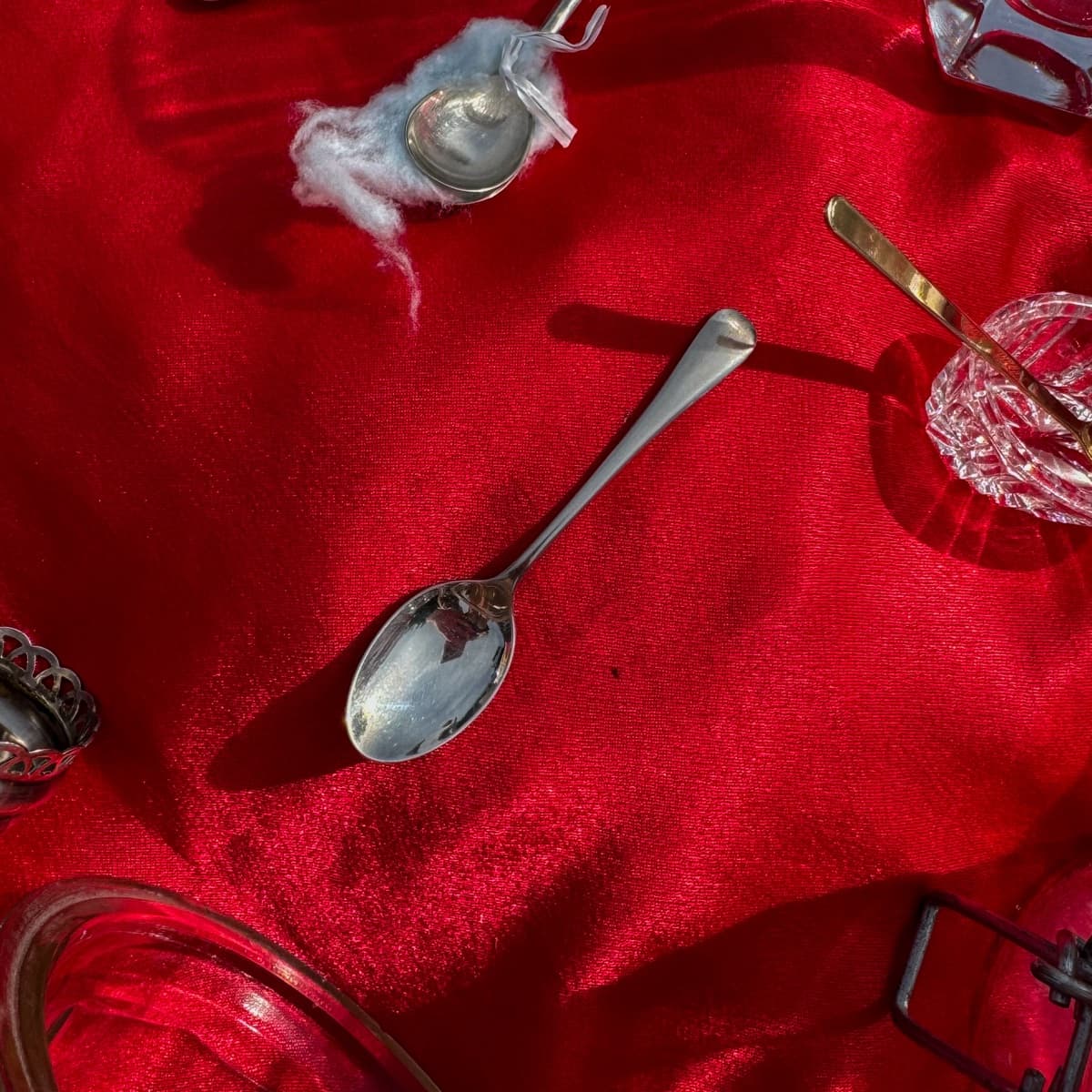 A silver teaspoon on red velvet at an antique stall